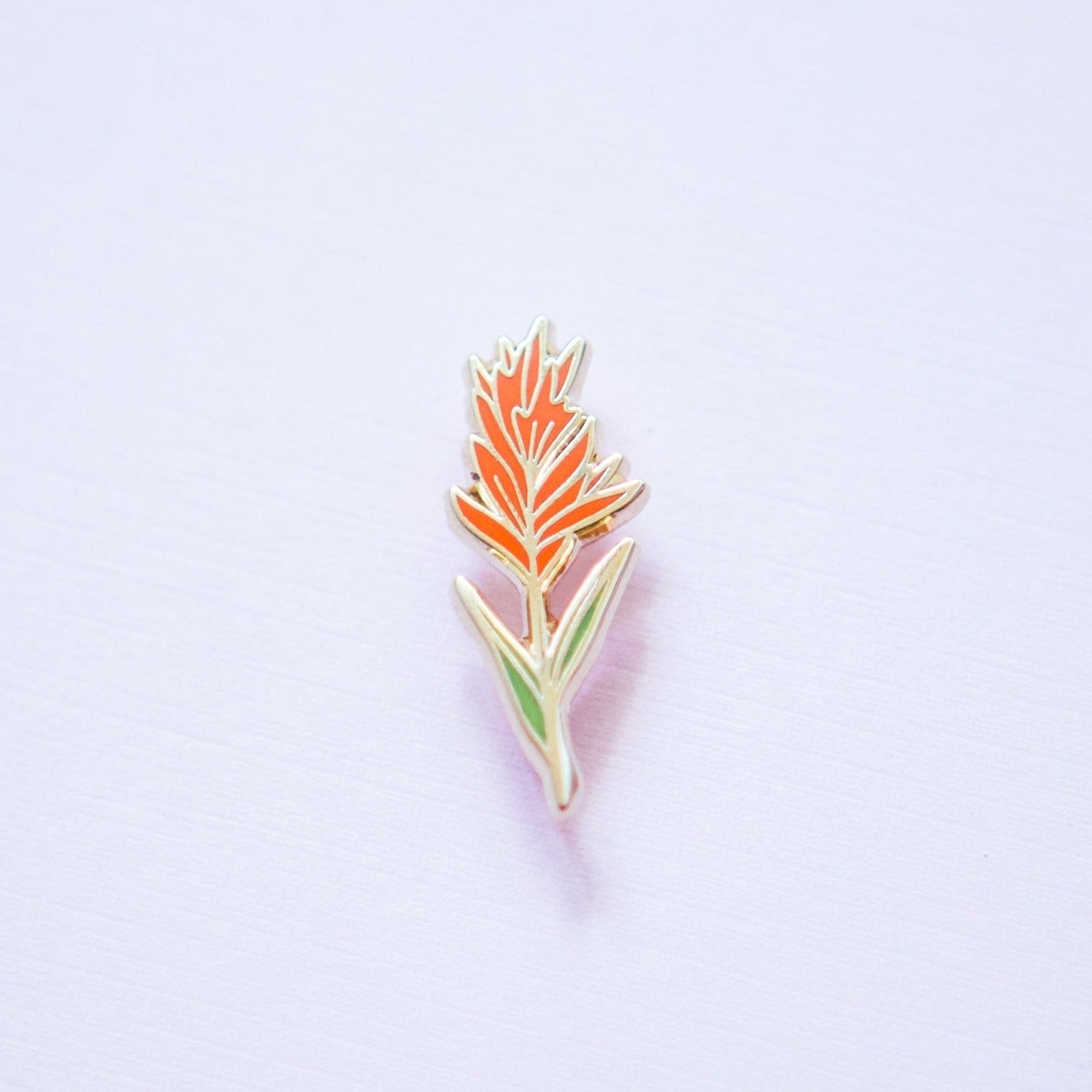 an indian paintbrush plant wildflower enamel pin made from red and green hard enamel and gold metal plating